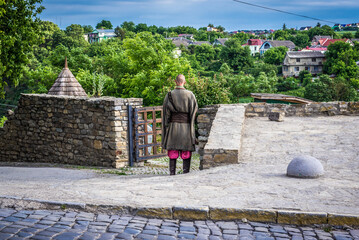 Man dressed as a Cossack in front of restaurant in historic part of Kamianets Podilskyi city, Ukraine