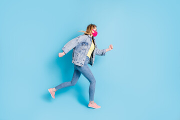 Full size profile photo of pretty lady quarantine finished run street outdoors jump high good mood shopping center direction wear face mask blazer jeans shoes isolated blue color background