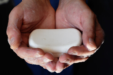 Man's hand holding a soap, man hands holding white antibacterial soap, self hygiene concept, covid-19 prevention