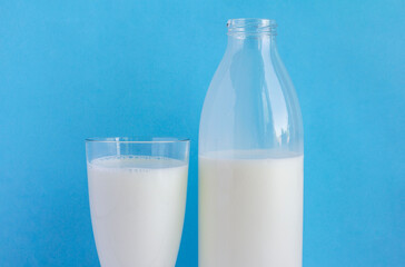 An open milk bottle and a glass of milk on a blue background