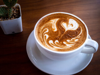 Coffee cup latte art on the wood table
