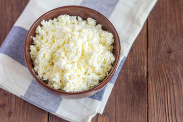 Cottage cheese.Rustic cottage cheese in a bowl on a wooden rustic table, top view.