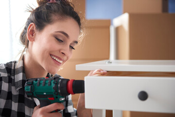 Close up of cheerful woman using electronic drill