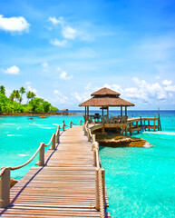 Sea with pier under blue cloudy sky