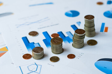 Concept of financial economic data growth -- office supplies such as coins and abacus placed on financial data statements