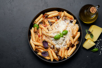 Penne pasta with eggplant, tomatoes and parmesan cheese. Traditional italian food