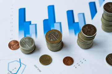Concept of financial economic data growth -- office supplies such as coins and abacus placed on financial data statements