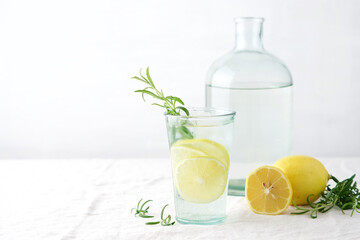 Lemon with rosemary summer cocktail or lemonade. Cold refreshment non-alcohol drink with lemon in glass