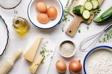 Ingredients for cooking vegetable pie on white wooden table.  Various cooking utensils and ingredients for zucchini cake recipe. Top view, flat lay