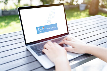 Person using a laptop computer with email communication connection message online and chat on social media with global letters concept.