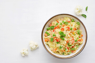 Cauliflower rice in a bowl on a white background. Paleo Food Diet Concept