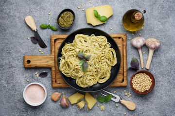Spaghetti with pesto sauce surrounded by traditional ingredients. Traditional Italian food. Flat lay