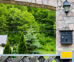 Mailbox on the fence of the house. In the background a beautiful house