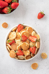 Tiny pancake cereal in a bowl with strawberry