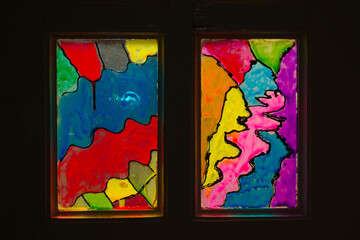 Multi-colored stained-glass windows in an old wooden door. Abstract pattern on glass.