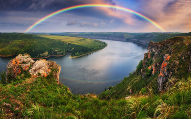 colorful rainbow over river canyon