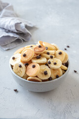 Tiny pancake cereal in a bowl with banana and chocolate chips