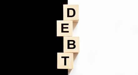 DEBT text on wooden blocks, financial business concept, black and white background