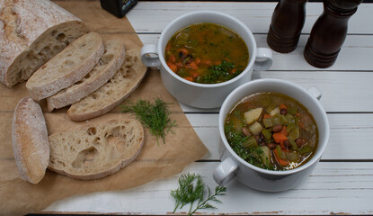 Italian vegan minestrone in white ceramic bowls served with home made ciabatta