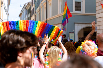 Young people hold a rainbow made of paper at a gay parade (LGBT Pride)