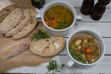 Italian vegan minestrone in white ceramic bowls served with home made ciabatta