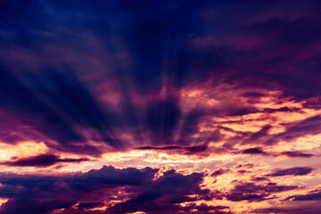 Fototapeta premium Dramatic sky with sunbeams breaking through the clouds