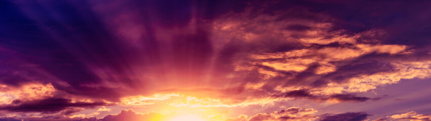 Rays of the setting sun breaking through the clouds web banner