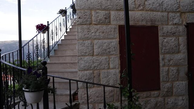 Young Caucasian woman walking down outside narrow cement residential steps with handrail, portrait close up pan