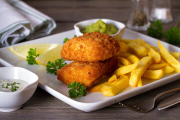 Fish and chips served with lemon, mushy peas and sauce. Battered fish with french fries