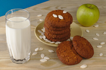 Daily healthy breakfast. Homemade oatmeal cookies, milk, fruit on wooden background.