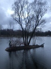 Obraz premium Island with sculpture in the lake in the park in autumn
