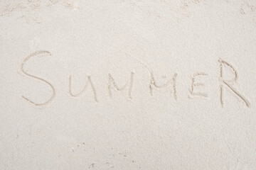 Concept: SUMMER word on white clean sand.