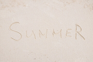 Concept: SUMMER word on white clean sand.