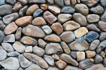 Wall background of rural buildings paved with large cobblestones