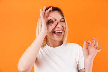 Image of joyful caucasian woman smiling and gesturing ok sign