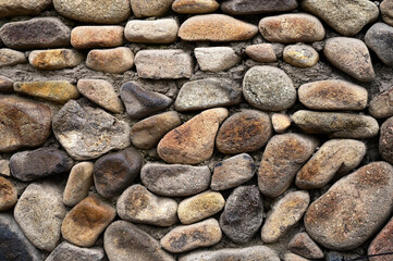 Wall background of rural buildings paved with large cobblestones