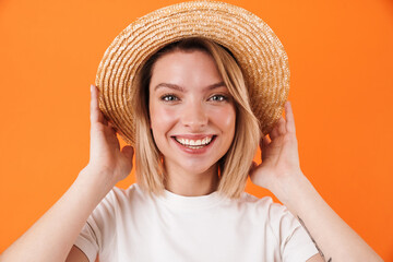 Image of happy cute woman in straw hat smiling and posing on camera