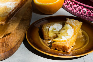 Homemade citrus tart with slices of lemon and oranges on top.