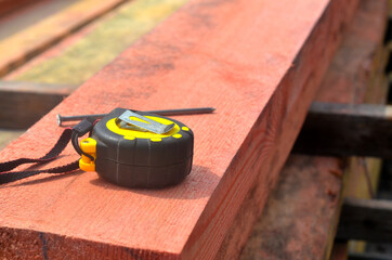 Close-up of construction roulette lying on the wooden board, construction work.