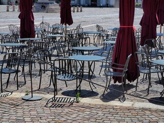 Empty bar terrace in deserted city for nationwide lockdown caused by Coronavirus epidemic emergency narrow foreground focus Turin Italy May 4 2020