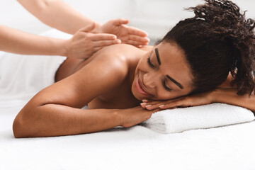 Obraz na płótnie Canvas Closeup of african young woman getting back massage