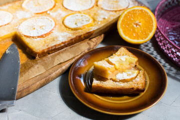 Homemade citrus tart with slices of lemon and oranges on top.