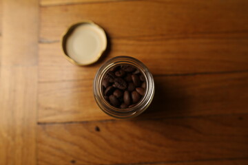 Coffee beans in a jar. Top view. Jar with coffee beans on a wooden background
