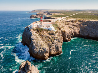 Beautiful lighthouse located on high cliffs of Saint Vincent cape in Algarve, Portugal - obrazy, fototapety, plakaty