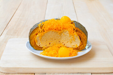 Egg custard in pumpkin on wood