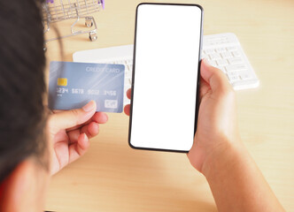 Woman holding smartphone with a blank screen and credit card mockup at office desk, concept financial transaction..