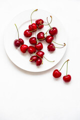 Naklejka na ściany i meble Juicy cherries on a white plate