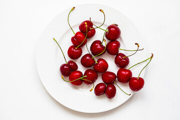 Naklejka na ściany i meble Juicy cherries on a white plate