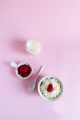 Rice pudding with frozen berries on a pink background, top view, flat lay. Vertical