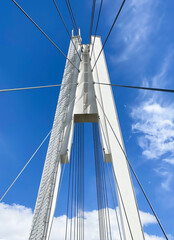 beautiful white bridge on the background of blue sky and air flying clouds view from below